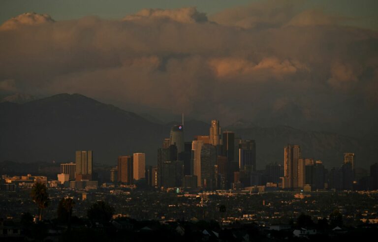 A fire rages Wednesday in the hills of Los Angeles, destroying dozens of homes