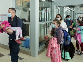 Des ressortissants ukrainiens fuyant l'invasion russe en cours de l'Ukraine arrivent à l'aéroport international Richardson de Winnipeg le lundi 23 mai 2022.