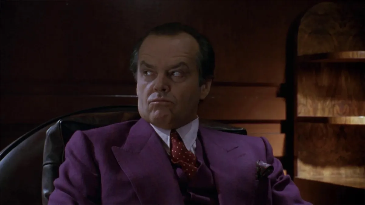 Jack Nicholson, dans le rôle de Jack Napier dans le film Batman de 1989, portant un costume violet.  Cette image fait partie d'un article sur l'origine du joker dans les bandes dessinées de Batman.