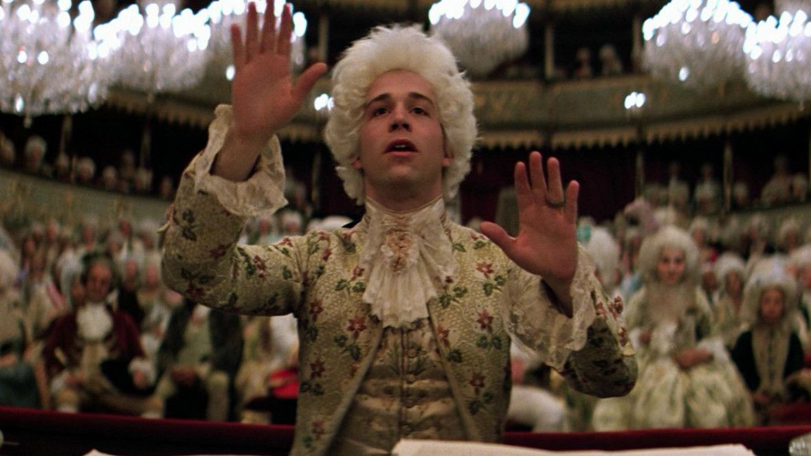Wolfgang Amadeus Mozart, les mains tendues, dirigeant une symphonie dans Amadeus