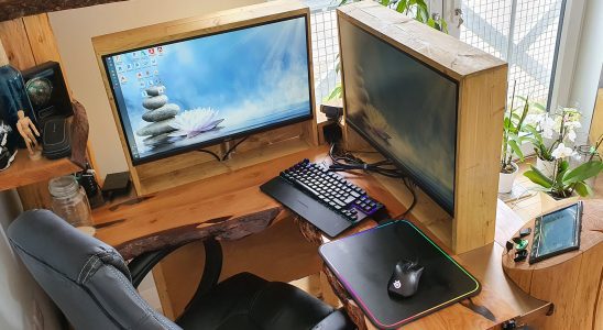 The wooden corner desk with two screens hidden by a wood panel