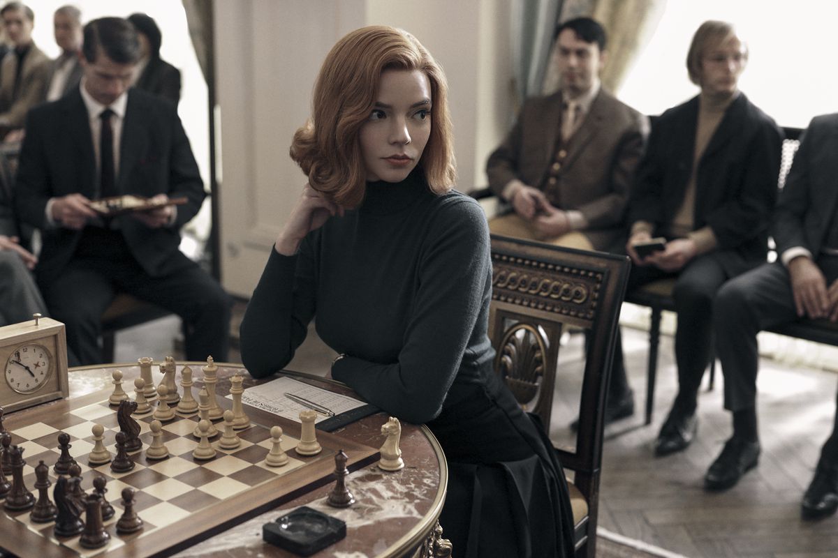 Queen's Gambit : Anya-Taylor Joy est assise sur un échiquier, entourée d'hommes