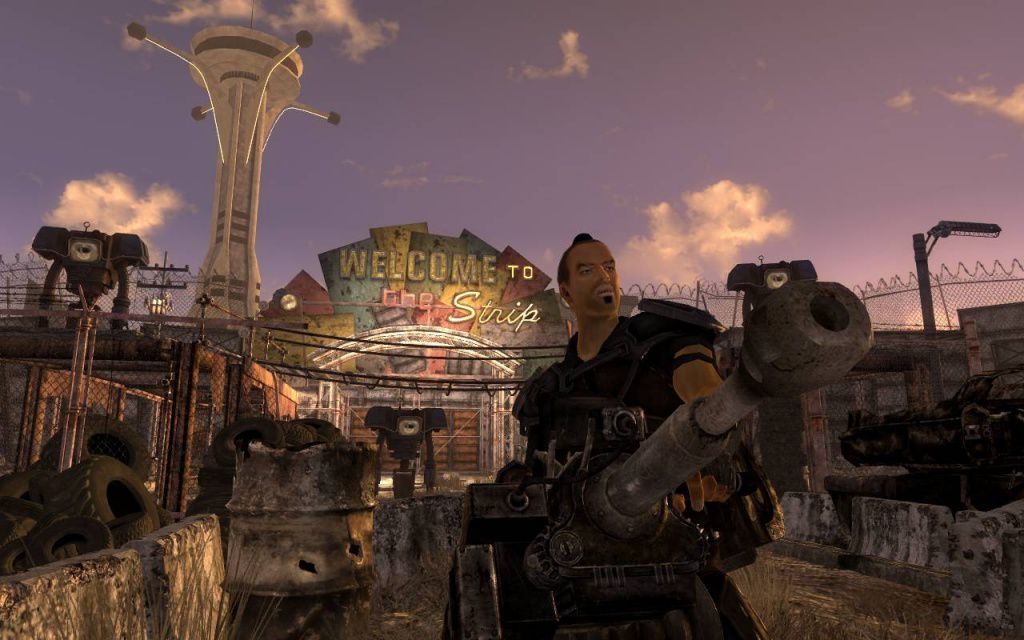 Une capture d'écran de Fallout : New Vegas d'un gars avec une arme à feu devant un panneau indiquant « Bienvenue sur le Strip » 