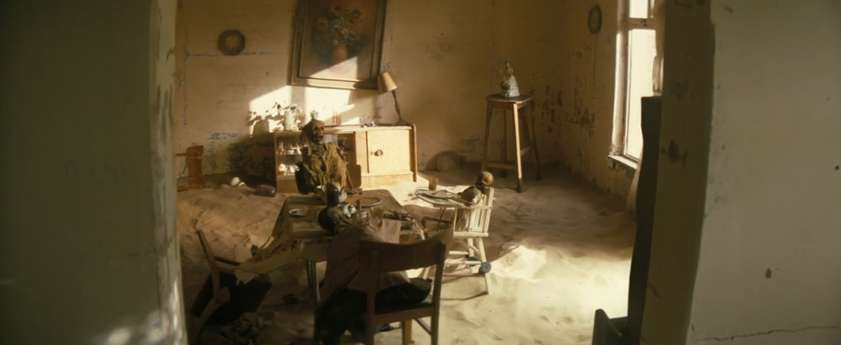Une photo de squelettes assis à table dans une maison déserte du désert de Fallout saison 1 épisode 2