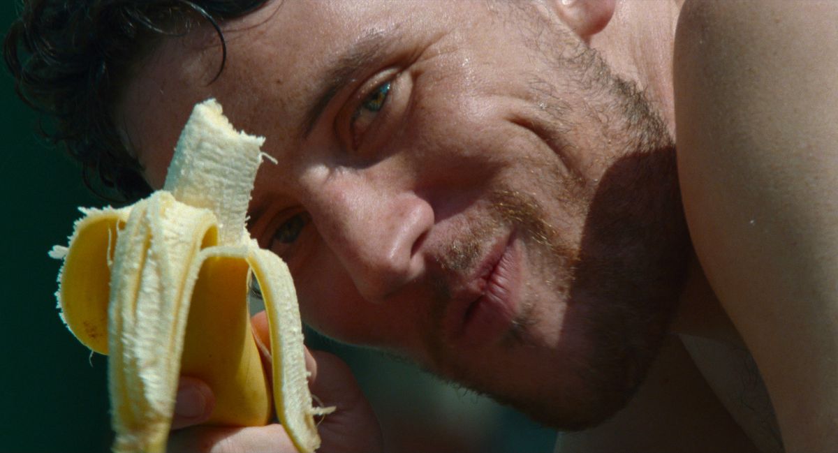 Patrick (Josh O'Connor), torse nu, débraillé et souriant, mange très ostensiblement une banane en très gros plan sur une photo de Challengers