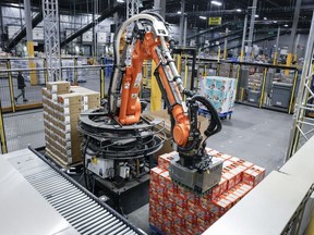 Un robot décharge une palette de nourriture pour chats dans un centre de distribution Walmart à Calgary, le jeudi 28 mars 2024.