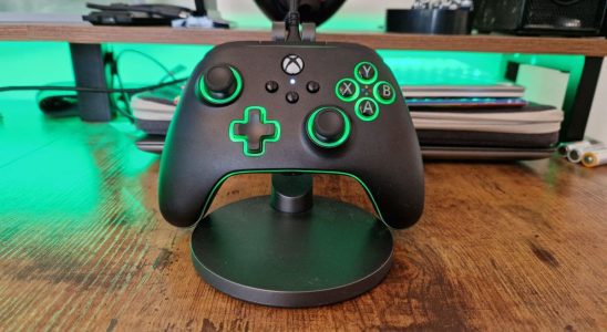 PowerA Advantage Controller review image of the gamepad sitting against a stand with green lighting on
