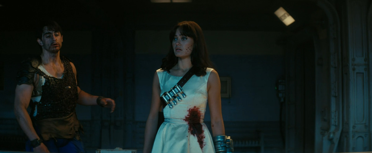 Lucy (Ella Purnell) dans une robe de mariée ensanglantée, avec des fléchettes tranquillisantes en bandoulière, dans Fallout