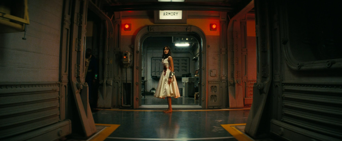 Au bout d'un couloir, Lucy (Ella Purnell) porte une robe de mariée ensanglantée dans Fallout
