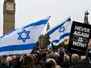 Des manifestants brandissent des drapeaux israéliens et tiennent des pancartes devant Big Ben, au Parlement, dans le centre de Londres, le 26 novembre 2023, lors d'une manifestation pour protester contre l'antisémitisme. 