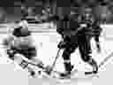 Josh Doan #91 des Coyotes de l'Arizona patine avec la rondelle contre Mattias Janmark #13 des Oilers d'Edmonton pendant la deuxième période du match de la LNH au Mullett Arena le 17 avril 2024 à Tempe, en Arizona.
