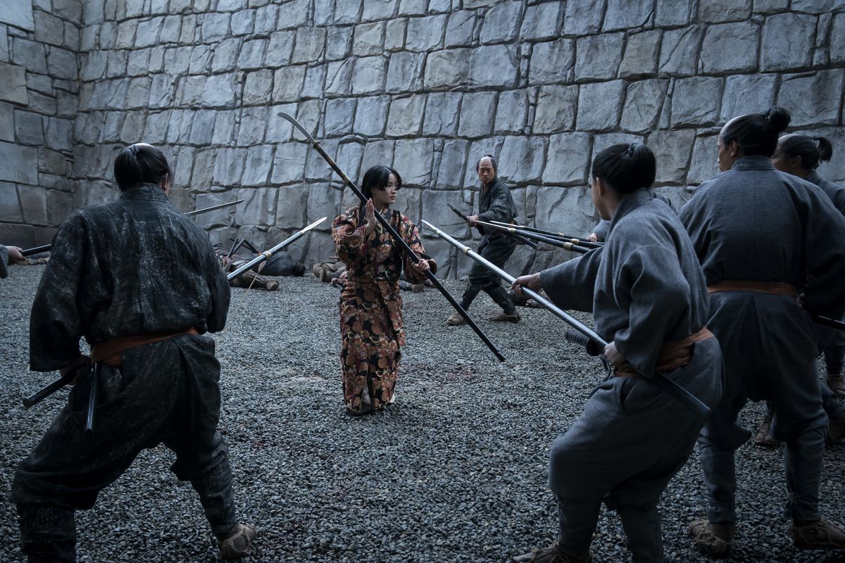 Anna Sawai brandit une naginata alors qu'elle est entourée d'hommes brandissant des lances dans Shogun