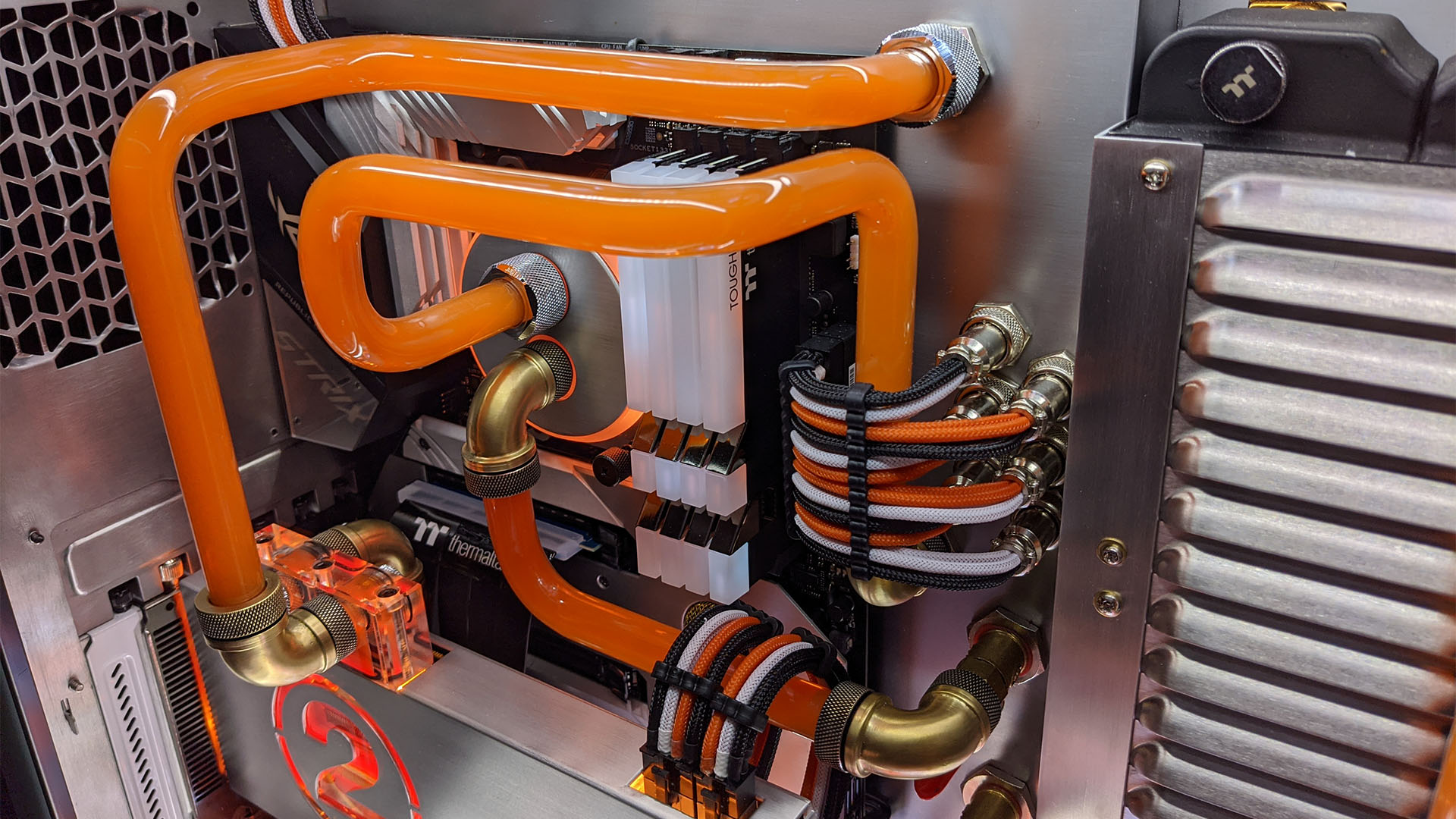Le PC de jeu avec raccords en laiton sur tuyaux de refroidissement à eau orange