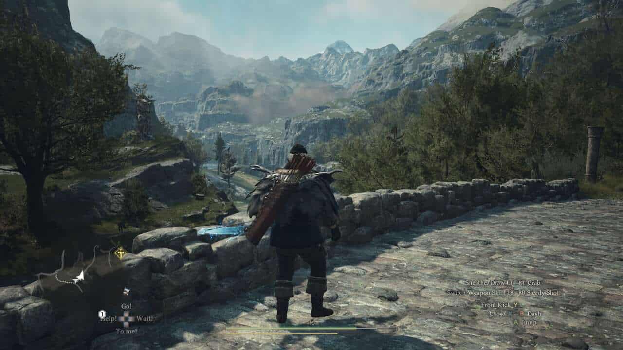 Dragon's Dogma 2 est génial, si vous prenez votre temps : un joueur debout sur un pont de pierre regardant vers un paysage montagneux.