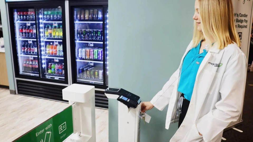 Un personnel médical scanne un badge dans un kiosque Just Walk Out alimenté par Amazon dans un hôpital.
