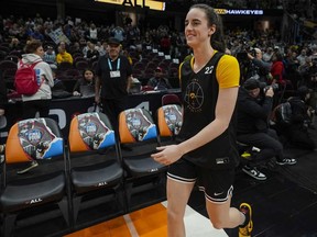 Caitlin Clark, de l'Iowa, sourit alors qu'elle arrive à l'entraînement pour le match de basket-ball du championnat NCAA Women's Final Four, le samedi 6 avril 2024, à Cleveland.