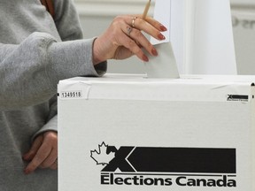 Un électeur dépose son bulletin de vote par anticipation à Chambly, au Québec, le vendredi 10 septembre 2021.