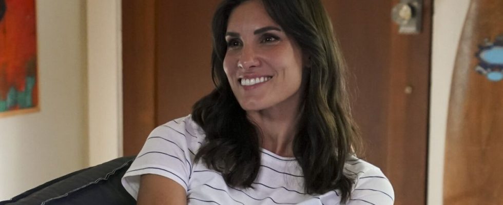 Kensi smiling on couch in striped shirt on NCIS: Los Angeles