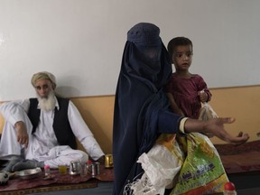 Ottawa a des plans pour garantir que l’aide canadienne puisse enfin parvenir à l’Afghanistan cette année.  Mais lorsque leur nouveau système sera pleinement opérationnel, les talibans auront contrôlé le pays depuis environ trois ans.  Une femme portant une burqa mendie en portant sa fille dans un salon de thé à Kaboul, en Afghanistan, le jeudi 8 juin 2023.