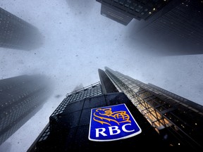 La neige tombe autour du siège social de la Banque Royale à Toronto.