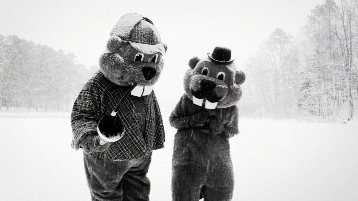 Deux personnes en costumes de castor de la taille d'une mascotte portent une tenue de Sherlock et Watson dans la neige dans Des centaines de castors