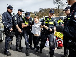 La militante suédoise pour le climat Greta Thunberg est arrêtée lors d'une marche pour le climat contre les subventions aux énergies fossiles près de l'autoroute A12 à La Haye, le 6 avril 2024. Des dizaines de policiers, certains à cheval, ont empêché les manifestants d'atteindre l'artère A12 menant à la ville balnéaire néerlandaise. , théâtre d'actions précédentes organisées par le groupe Extinction Rebellion (XR).