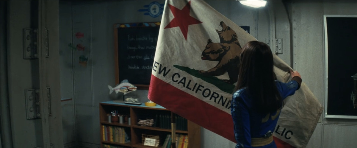 Lucy (Ella Purnell) brandissant le drapeau de la République de Nouvelle-Californie dans l'Abri 4