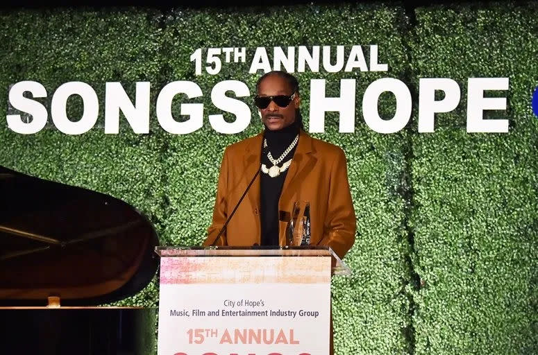 Le rappeur Snoop Dogg se tient sur un podium avec le texte 