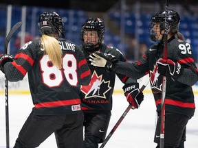 Renata Fast (14 ans) du Canada célèbre son but contre la Suède avec ses coéquipières Julia Gosling (88 ans) et Danielle Serdachny (92 ans) lors de la deuxième période de quart de finale au Championnat mondial de hockey féminin de l'IIHF à Utica, NY, le jeudi 11 avril 2024.