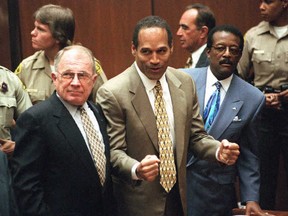 L'accusé pour meurtre OJ Simpson (au centre) écoute le verdict de non-culpabilité avec ses avocats F. Lee Bailey (à gauche) et Johnnie Cochran Jr. (à droite) à Los Angeles le 3 octobre 1995.