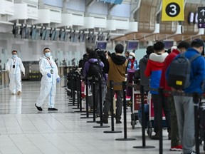 Des gens font la queue et s'enregistrent pour un vol international à l'aéroport international Pearson pendant la pandémie de COVID-19 à Toronto, le mercredi 14 octobre 2020.