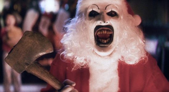 David Howard Thorton as Art the Clown, laughing while dressed as Santa with an axe, in Terrifier 3.