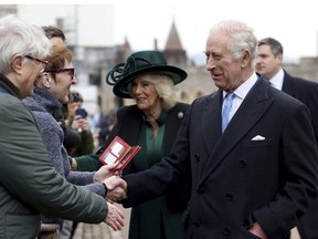 Le roi Charles III de Grande-Bretagne et la reine Camilla saluent les gens après avoir assisté au service des Matines de Pâques à la chapelle Saint-Georges, au château de Windsor, en Angleterre, le dimanche 31 mars 2024.