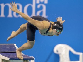 Maggie Mac Neil décolle du bloc de départ en route pour remporter le 100 mètres papillon féminin LC aux essais canadiens de natation à Toronto le mercredi 29 mars 2023.