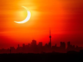 Une éclipse solaire annulaire s'élève au-dessus de l'horizon de Toronto le jeudi 10 juin 2021.