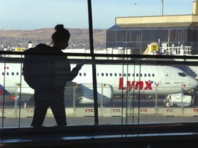 Un passager d'une compagnie aérienne passe devant le nouveau Boeing 737 de Lynx Air sur le tarmac de l'aéroport international de Calgary, à Calgary, le jeudi 7 avril 2022.