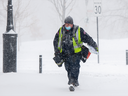 Un employé de Postes Canada livre le courrier lors d'une tempête de neige à Montréal.