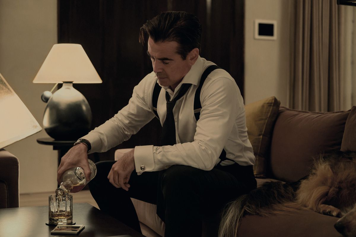Colin Farrell verse un verre de scotch dans ses bretelles avec sa cravate desserrée dans l'émission Sugar d'Apple TV Plus
