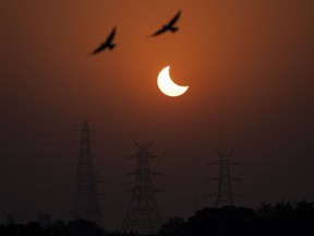 Alors que l'éclipse solaire de lundi devrait attirer des milliers de personnes dans les régions situées le long du chemin de totalité de l'Est du Canada, les principaux fournisseurs de téléphonie mobile et Internet se disent prêts à faire face à une perturbation du trafic sans fil dans ces régions.  Des aigles survolent une éclipse solaire partielle à New Delhi, en Inde, le mardi 25 octobre 2022.
