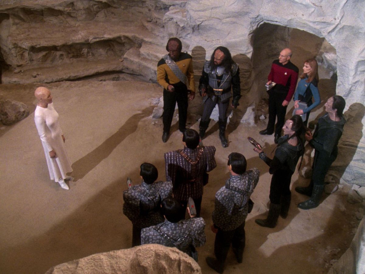 L'hologramme Progenitor apparaît devant un groupe de capitaines et membres d'équipage romuliens, klingons, cardassiens et Starfleet dans Star Trek : The Next Generation.