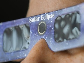 Les éclipses totales de Soleil, comme celle très attendue de lundi prochain, sont souvent considérées comme des expériences visuelles.  Une personne porte une paire de lunettes à éclipse solaire approuvées par la NASA à Montréal, le mardi 2 avril 2024.