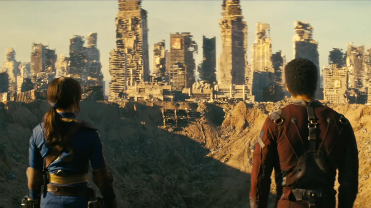L'émission télévisée Fallout, avec Lucy et Maximus regardant un immense cratère entouré de bâtiments en ruines. 