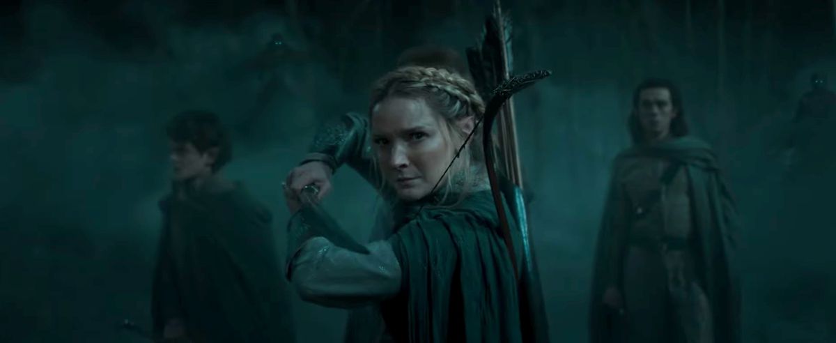 Galadriel (Morfydd Clark) tenant une épée avec des gens derrière elle