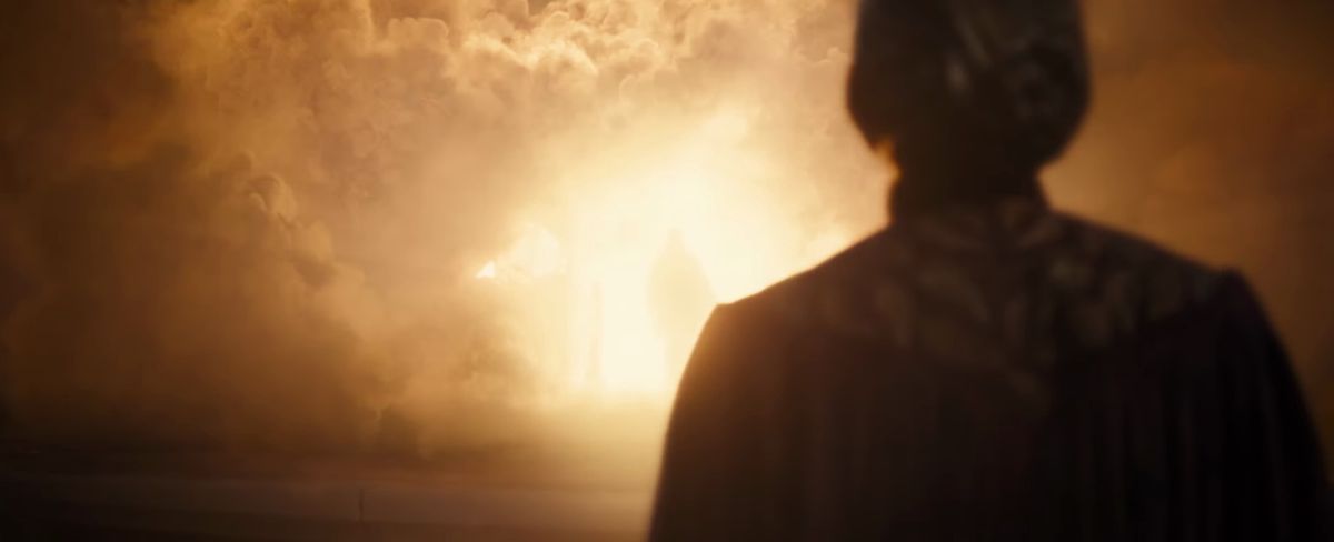 Celebrimbor se tient devant un immense feu lumineux et enfumé, avec une silhouette debout en son centre lumineux dans la bande-annonce de la saison 2 du Seigneur des Anneaux : Les Anneaux du Pouvoir.