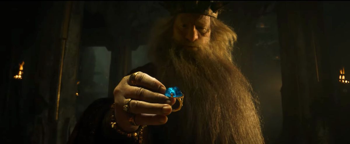 Le roi Durin ramasse un anneau en or sur lequel est sertie une énorme pierre précieuse bleue dans Le Seigneur des Anneaux : Les Anneaux du Pouvoir.