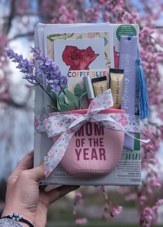 image d'une boisson koozy qui dit maman de l'année avec des bonbons et des fleurs qui sortent du dessus, le tout posé sur un livre 