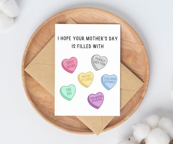 carte blanche à deux volets avec des coeurs de bonbons marqués de tropes romantiques et du titre "J'espère que la fête des mères sera remplie de"