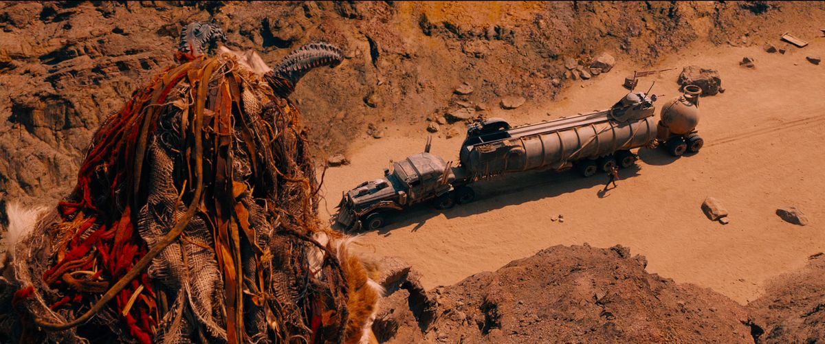 Un cavalier de rock scrute le flanc d'une falaise pour observer le War Rig de Furiosa dans Mad Max : Fury Road