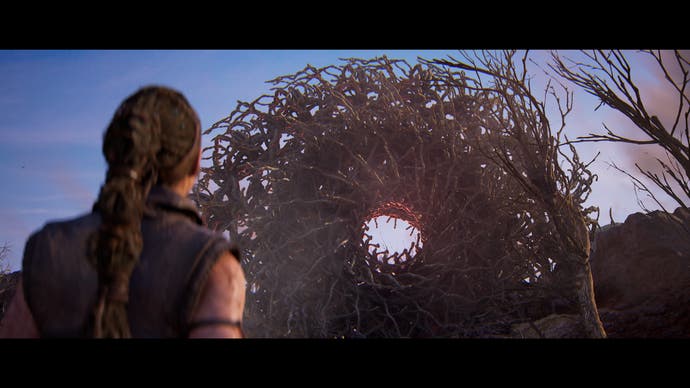 Capture d'écran de Hellblade 2 montrant Senua debout devant une grande barrière circulaire faite de bâtons imbriqués