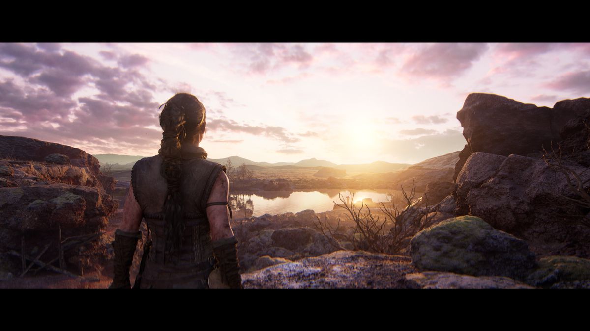 Senua de Hellblade 2 regarde un magnifique lever de soleil sur un paysage accidenté